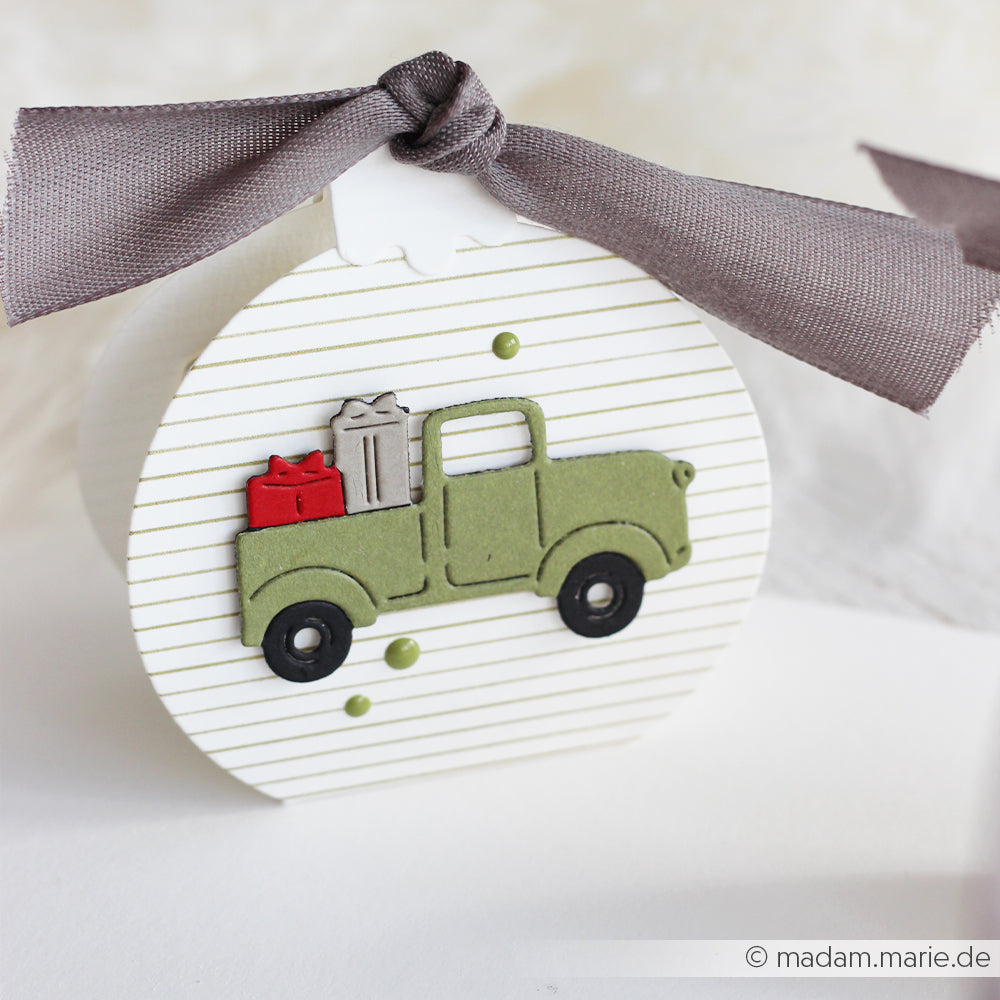 Eine runde Geschenkbox in der Farbe Zarte Streifen Sanftgrün mit einem grünen Pick-up und einer grauen Schleife.