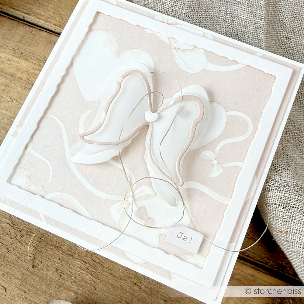 Handgefertigte Karte von Alexandra Renke mit Engelsflügeln, Herzformen und "Ja!" auf zartem beigem und weißem Hintergrund, hergestellt mit Stanzen für Designpapier und DieCut Systemen für komplizierte Details.