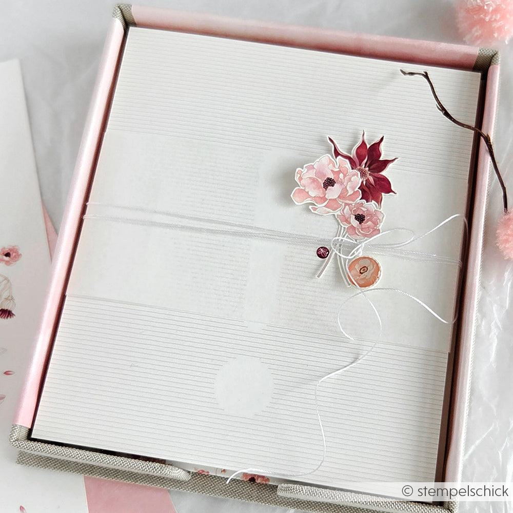 Eine dekorative weiße Karte mit rosa Blumen und Schnur von Alexandra Renke, hübsch verpackt in einer PAPPKit Zettelbox.