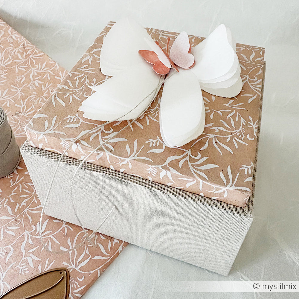 Alexandra Renke Geschenkbox: Mit ihrem floral gemusterten Deckel und dem großen weiß-rosa Papierschmetterling als Topper ist diese elegante Einsteckbox perfekt, um einen besonderen Anlass unvergesslich zu machen.