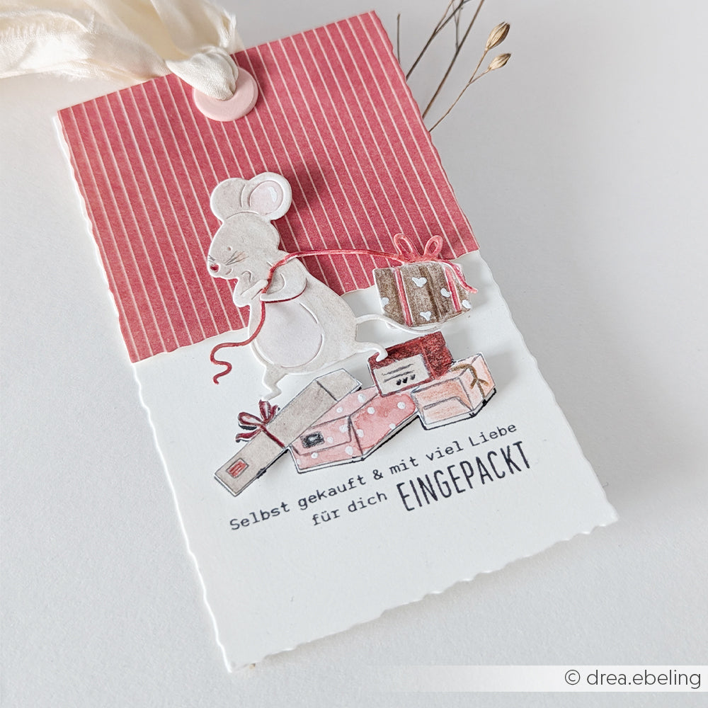 Geschenkanhänger mit einer Mausillustration und dem deutschen Text Selbst gekauft & mit viel Liebe EINGEPACKT, der mit einem Stempel aufgebracht wurde.