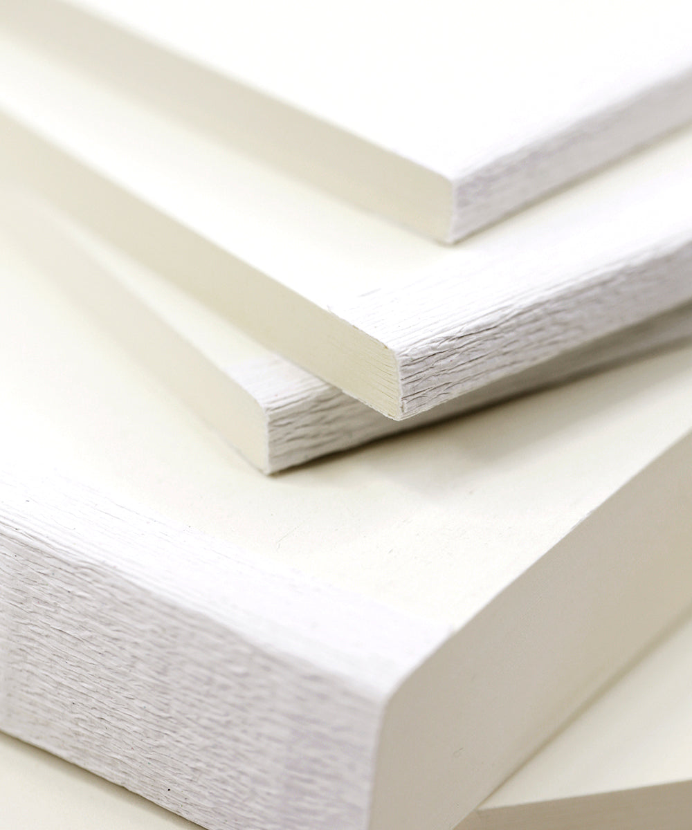 Nahaufnahme von gestapelten weißen Holzplatten mit sichtbarer Maserung und sauberen, scharfen Kanten.