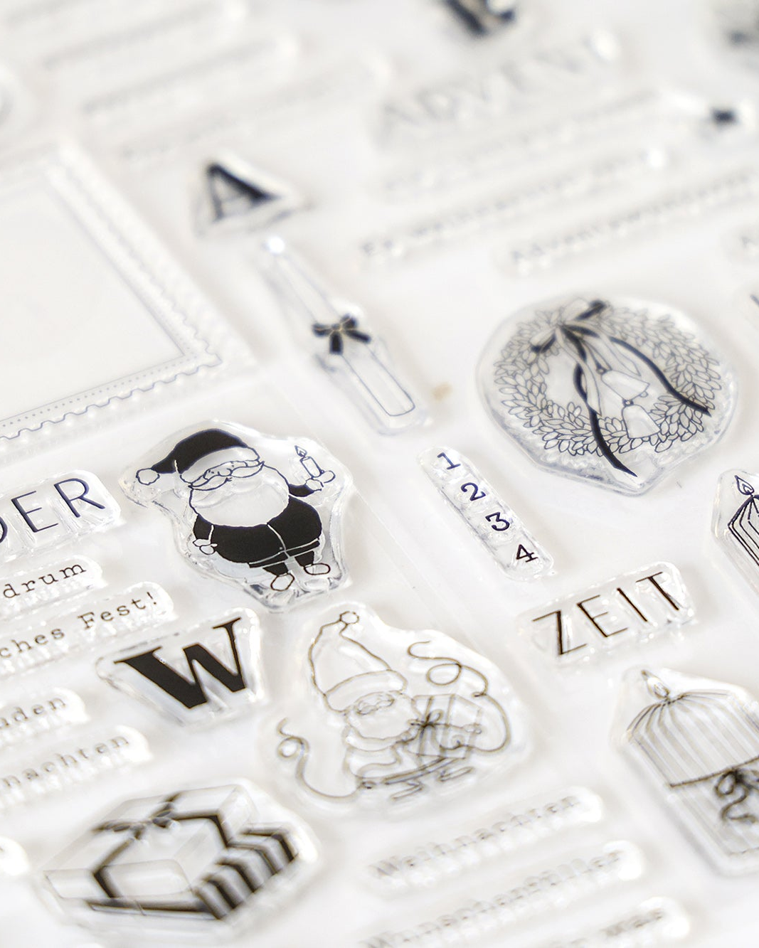 Klarsichtstempel mit Weihnachtsmann, Geschenken, Zahlen und weihnachtlichen Motiven auf weißem Hintergrund.