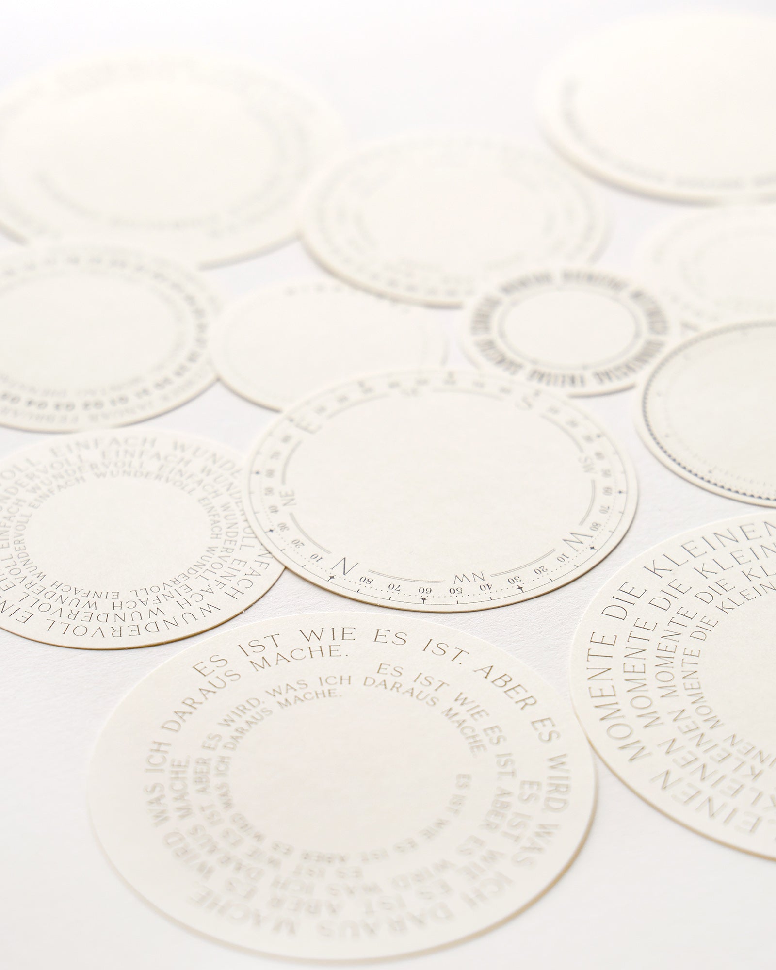 Bunte Scherenschnitte mit skurrilen Illustrationen und deutschem Text auf einer weißen Fläche.