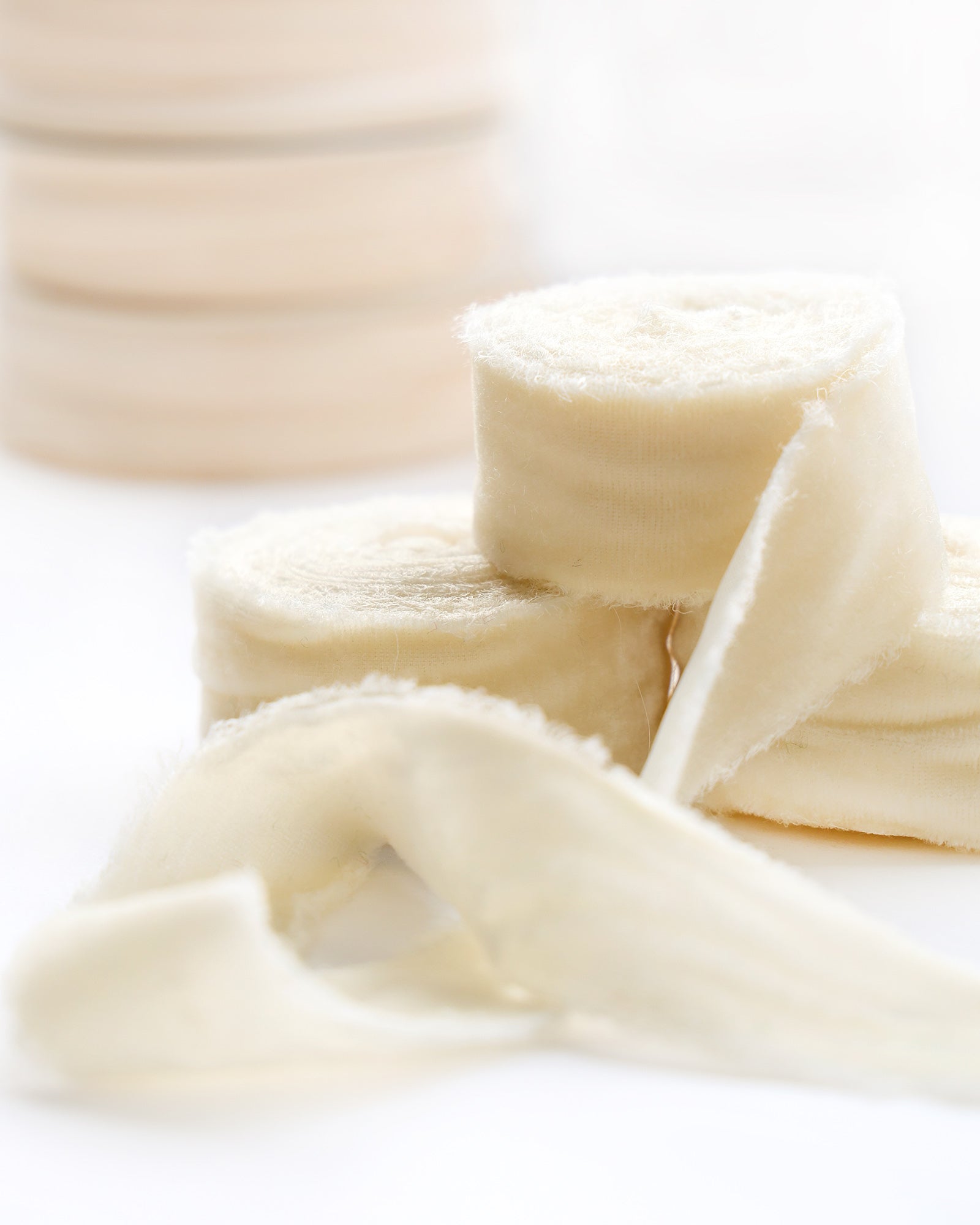 Nahaufnahme von weichen, gerollten medizinischen Verbänden auf einer weißen Fläche mit unscharfem Hintergrund.