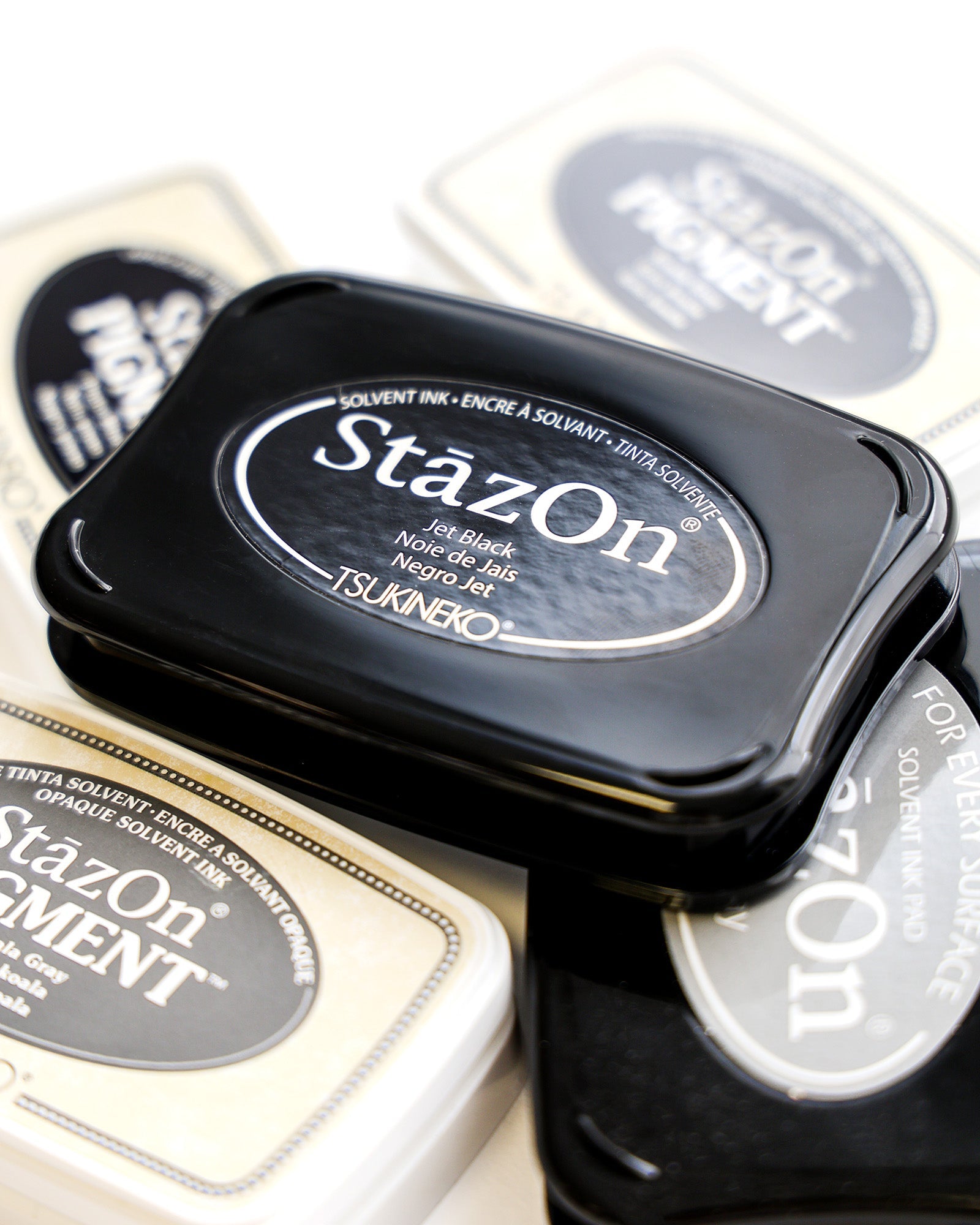 Nahaufnahme von StazOn- und StazOn-Pigment-Tintenkissen, mit einem schwarzen Stempelkissen oben in der Mitte.