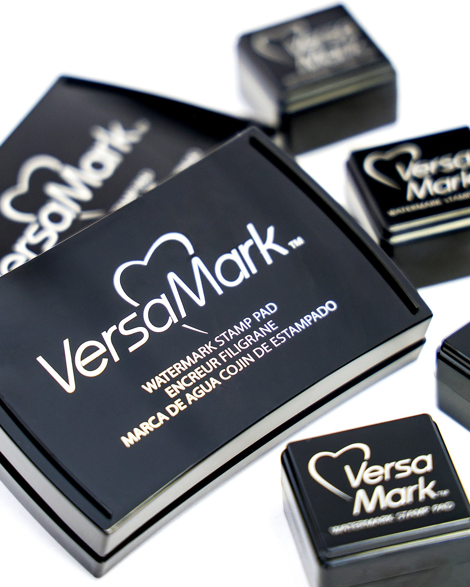 Mehrere schwarze VersaMark-Wasserzeichen-Stempelkissen auf einer weißen Fläche.
