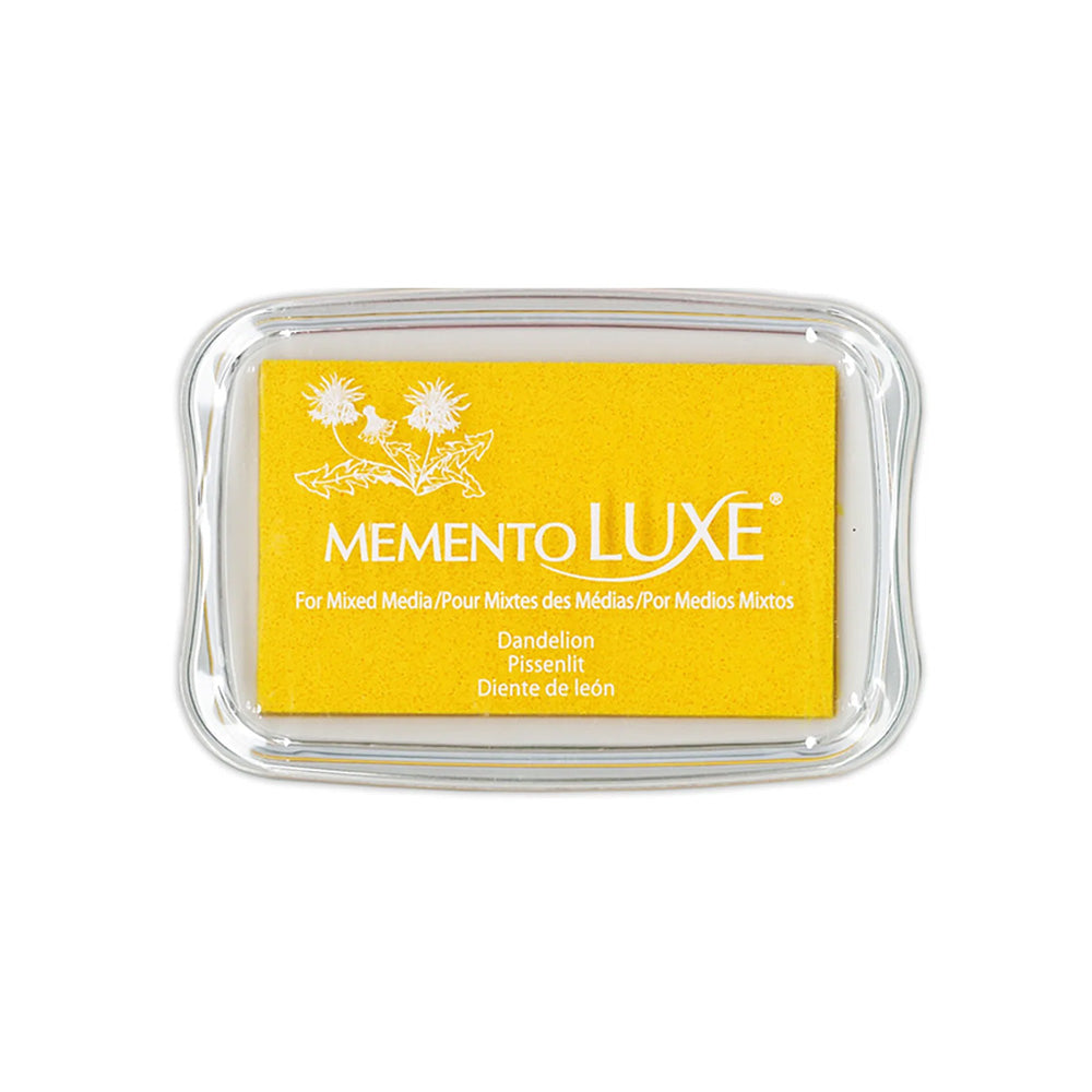 Das Tsukineko Memento Luxe Pigmenttintenkissen in Löwenzahn wird in einem durchsichtigen Kunststoffgehäuse mit weißen Blumenmustern geliefert - ideal für Stoffstempel und Bastelprojekte.