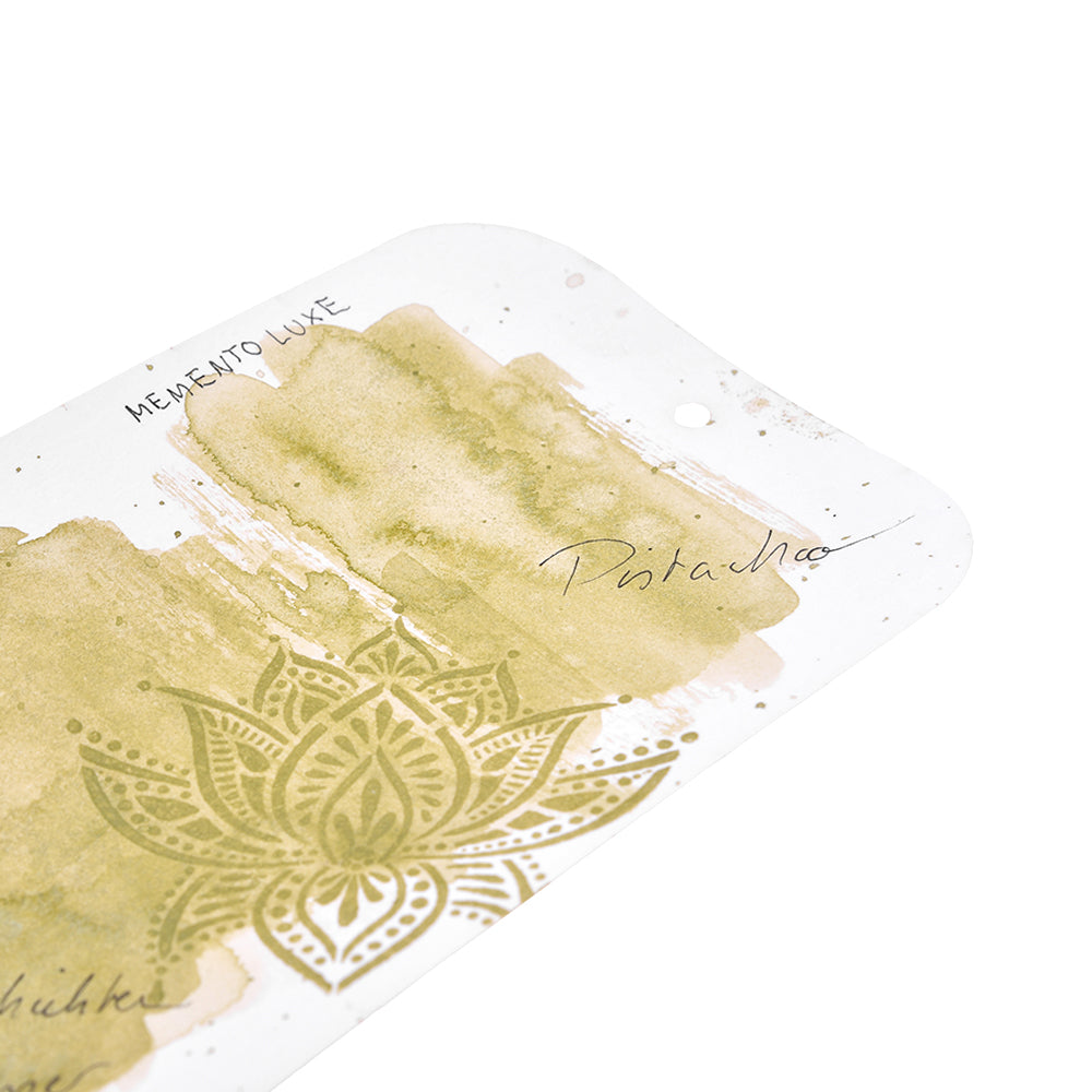 Nahaufnahme einer Karte mit der Aufschrift Pistazie mit grüner Aquarellfarbe und einem Mandala-Muster, hergestellt mit leuchtenden Tsukineko Pigment-Tinten - eine ideale Inspiration für Stempelkissen-Fans und Textilstempel-Projekte.