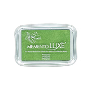 Ein grünes Tsukineko Memento Luxe-Pigmenttintenkissen in Pistazie, das sich in einem durchsichtigen Plastiketui befindet - perfekt als Stoffstempelkissen.