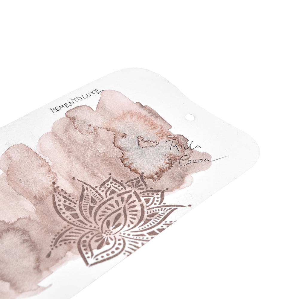 Eine Tsukineko-Karte mit brauner Aquarellmalerei, floralen Mustern und der handschriftlichen Aufschrift "Rich Cocoa" eignet sich perfekt für die Präsentation von Pigment-Tinten Stempelkissen oder Stempelkissen für Stoff.