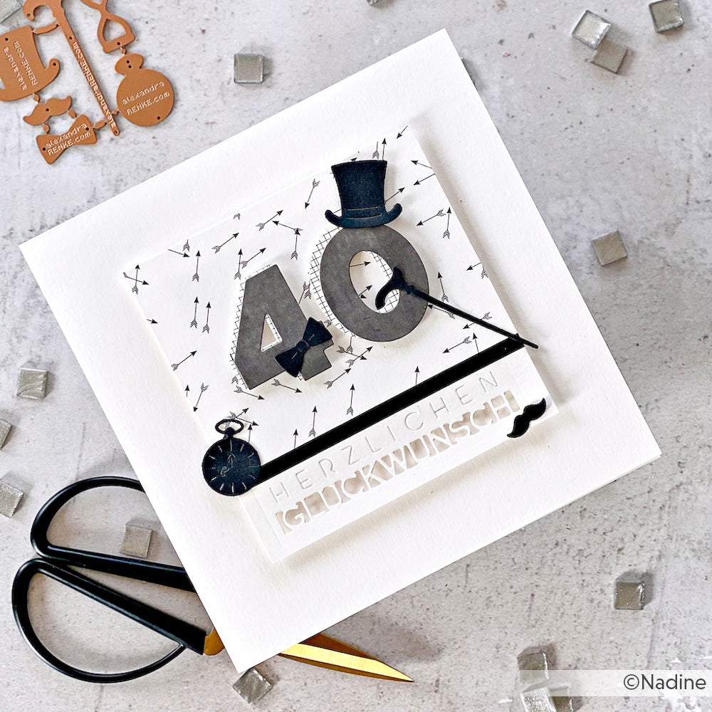 Handgemachte Alexandra Renke Karte mit "40" in Silber, Zylinder, Uhr und Pfeilen auf hochwertigem Designpapier mit deutschem Text - ideal für Papierprojekte. Die abgebildete Schere dient als Maßstab.