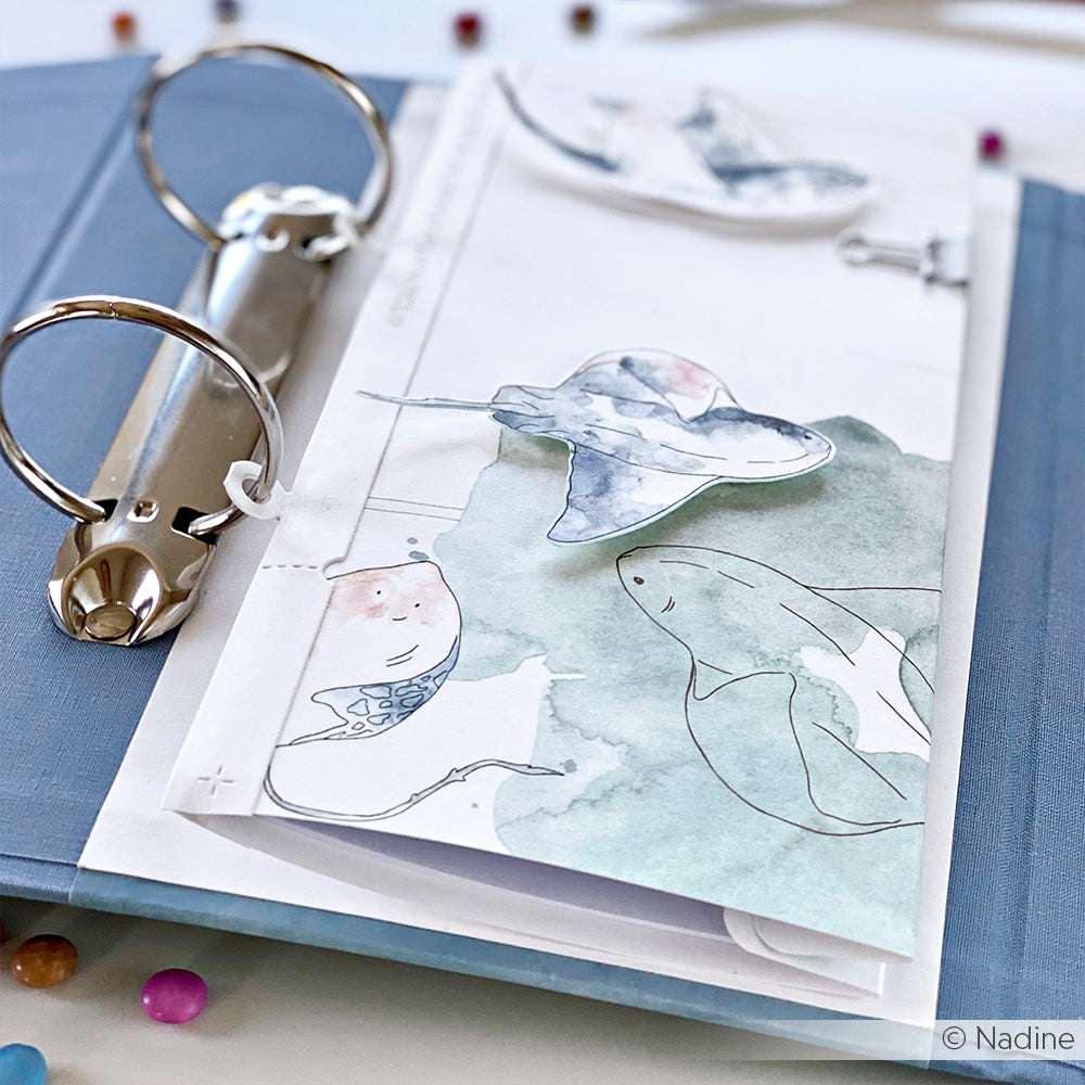 Alexandra Renke Mappe mit illustrierten Aquarell-Meerestieren wie einem Rochen und Wal, ausgestellt auf einem weißen Tisch - ideal für Papierprojekte oder als einzigartiges Designpapier.