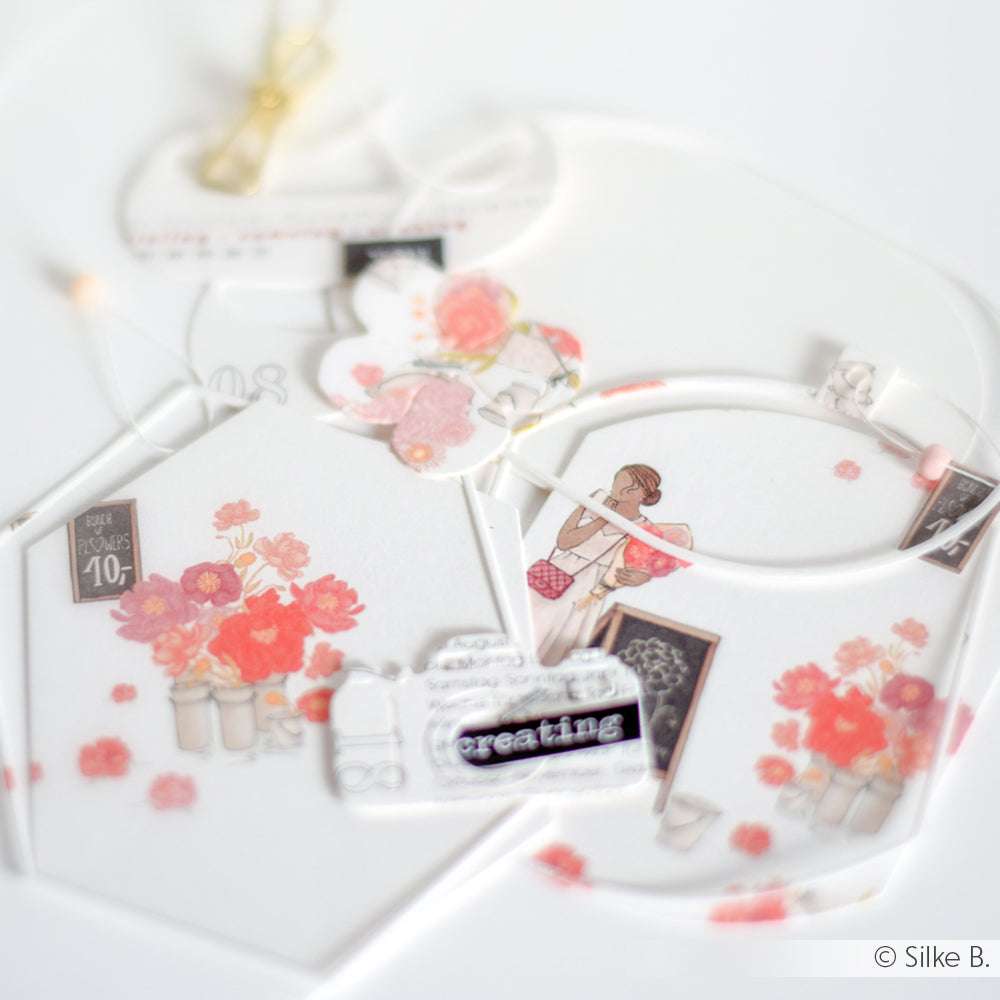 Alexandra Renke Designpapier mit floralen Motiven, einem Fotoapparat und einer Mädchenillustration auf Weiß - ideal für Papierprojekte oder den Charme eines Blumenmarktes.