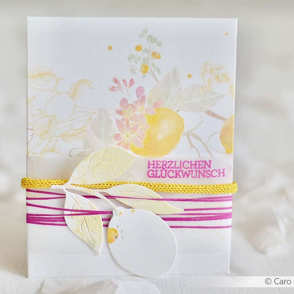 Eine Blumenkarte von Alexandra Renke, gestaltet mit dem Designpapier Herbarium Zitronenkranz - mit gelben Zitronen, rosa Kordel und leuchtend rosa "Herzlichen Glückwunsch"-Text; perfekt für Buchbinderei oder einzigartige Papierprojekte.