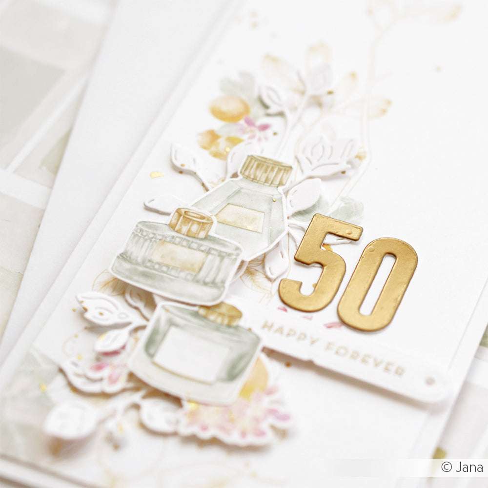 Alexandra Renke-Grußkarte mit Parfümflaschen-Illustrationen, einer goldenen "50", "Happy Forever"-Text und floralen Akzenten - ideal für Papierprojekte oder um Ihren Buchbinderei-Kreationen Eleganz zu verleihen.