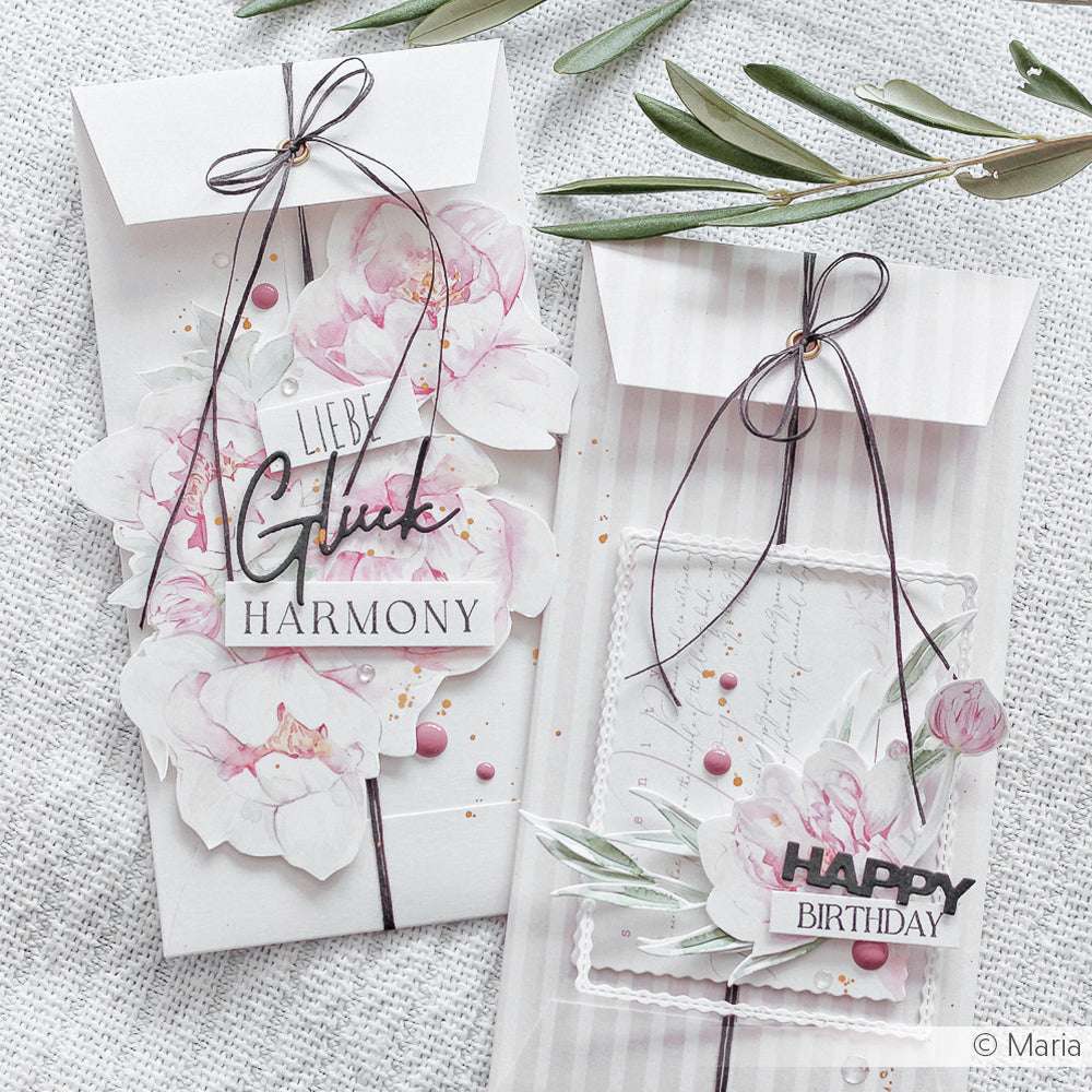 Zwei elegante florale Geburtstagskarten von Alexandra Renke aus Designpapier mit rosafarbenen Blumen, Schleifen und Grüßen in deutscher und englischer Sprache, schön arrangiert auf einer weißen Fläche.