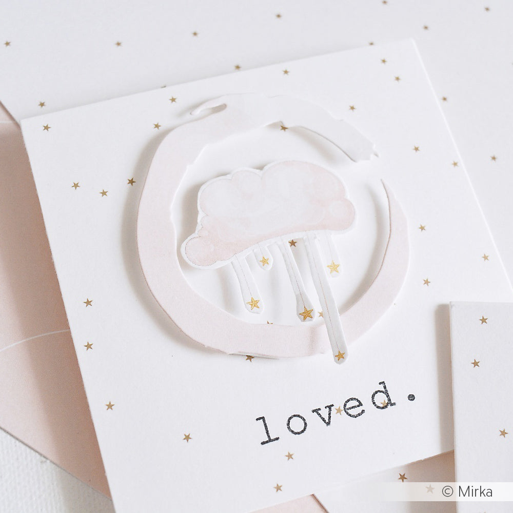 Eine pastellfarbene Karte von Alexandra Renke, die mit Designpapier gestaltet wurde, zeigt eine Wolken- und Mondillustration, winzige goldene Sterne und das Wort "Geliebt", das darunter steht.