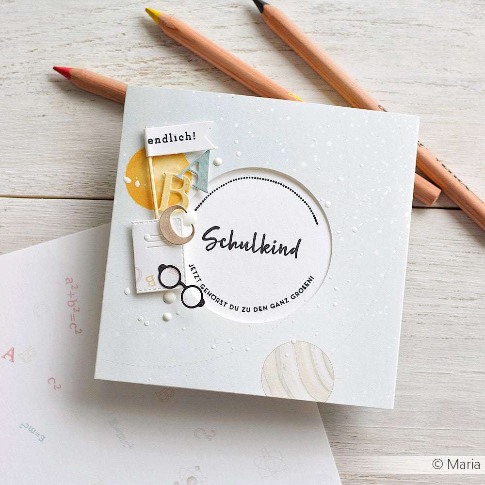 Quadratische Karte von Alexandra Renke mit Schulkind-Text, Schulmotiven und Buntstiften auf hochwertigem Designpapier - eine inspirierende Papierprojekte-Idee für Buchbinderei-Fans.