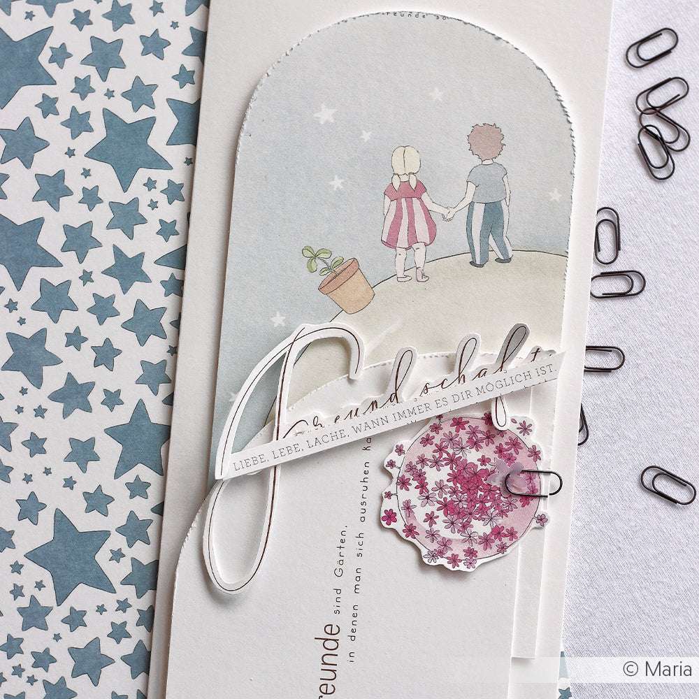 Grußkarte von Alexandra Renke mit zwei händchenhaltenden Kindern, dekorativen Sternen und deutschem Text auf hochwertigem Designpapier. Die nahegelegenen Büroklammern verleihen dieser entzückenden Papierprojekte-Kreation Buchbinderei-Charme.