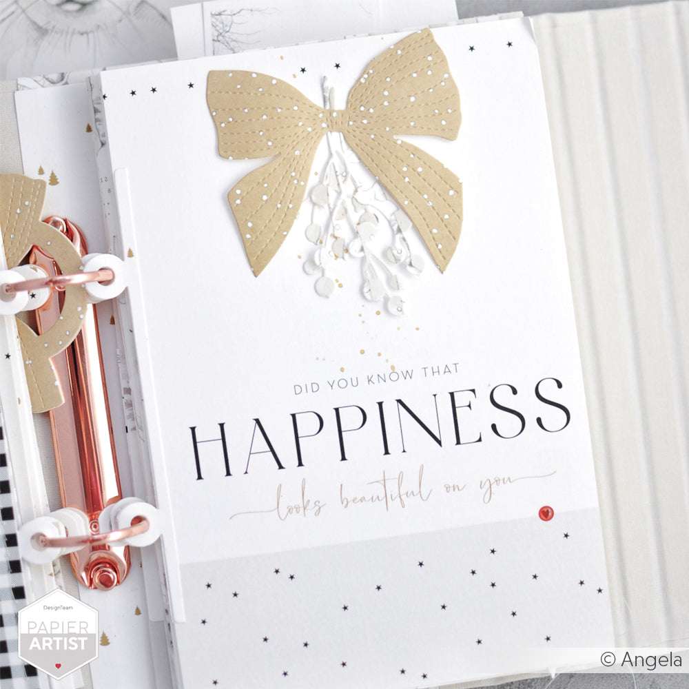 Eine weiße Karte von Alexandra Renke aus hochwertigem Designpapier ist mit einer goldenen Schleife und dem Text "Das Glück steht dir gut" versehen - eine charmante Wahl für Papierprojekte.