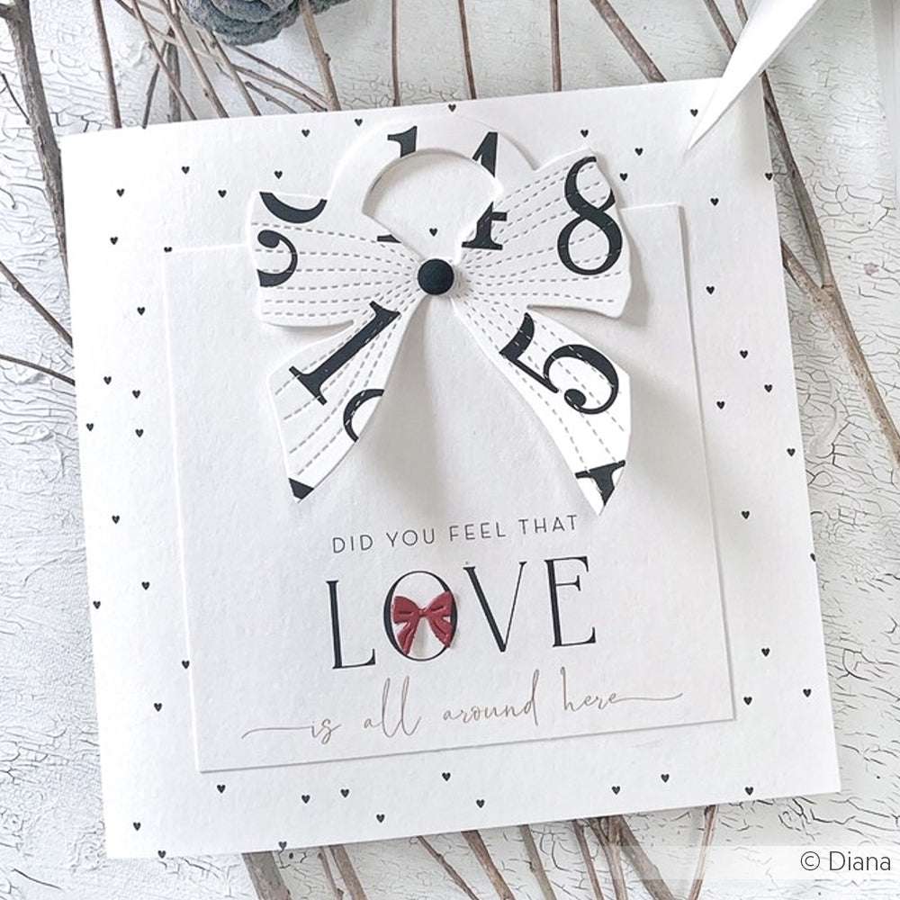 Quadratische Karte von Alexandra Renke mit einer schwarz-weißen Schleife und dem Text "Did you feel that LOVE is all around here" - perfekt für Papierprojekte oder um Ihre nächste Designpapier-Kreation mit Charme zu versehen.