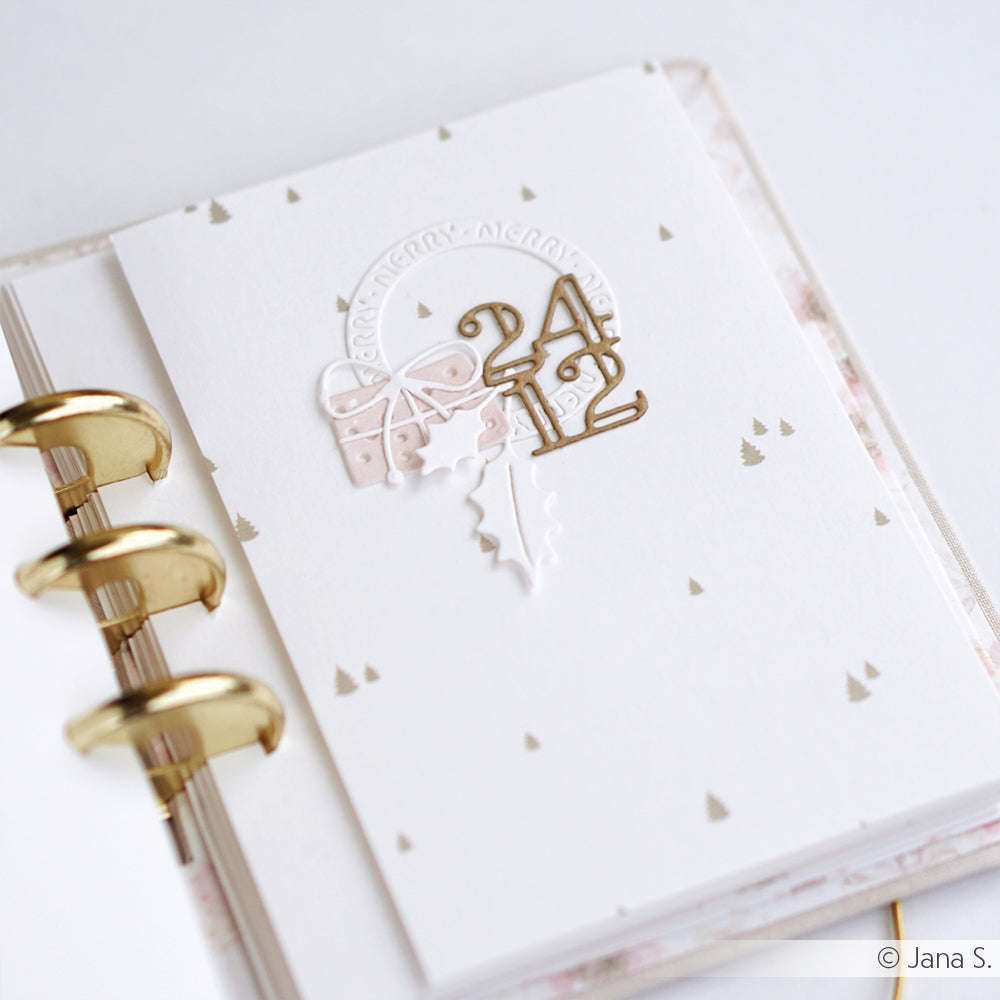 Weißes Planerblatt mit goldenen Ringen von Alexandra Renke, mit 24 12 weihnachtlichen Motiven - ideal für Papierprojekte oder zum Hinzufügen Ihrer Lieblingsakzente aus Designpapier.