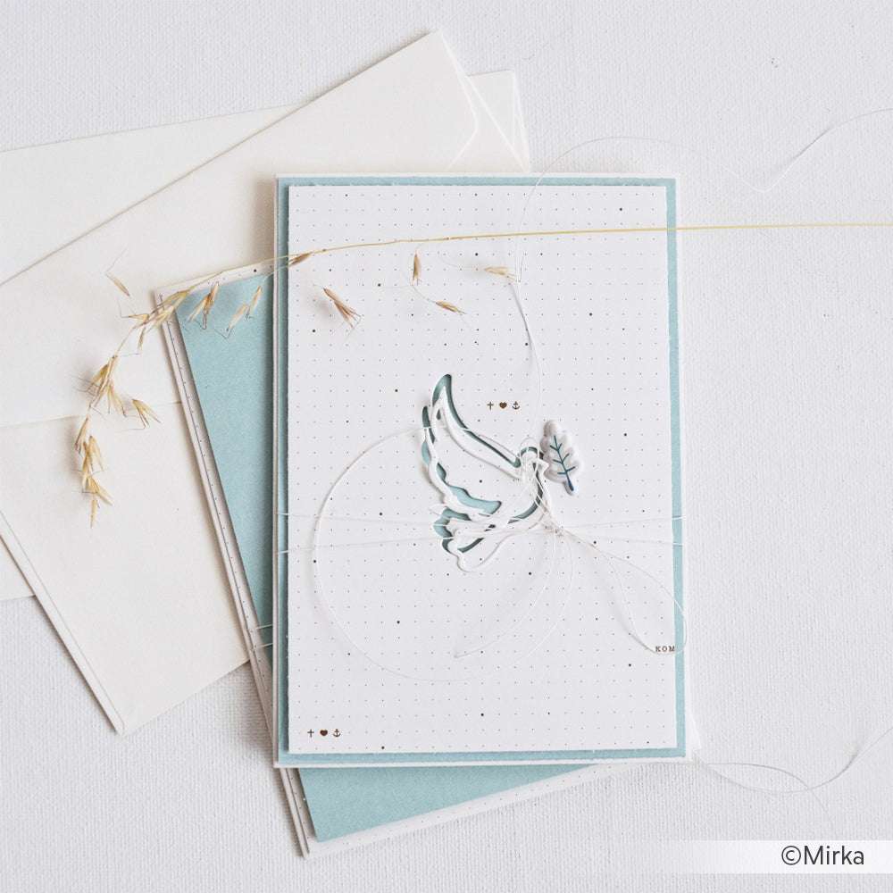 Eine handgefertigte Karte mit einem zarten Taubenmotiv aus Alexandra Renke Designpapier ruht auf einem blauen Umschlag und weißem Hintergrund - perfekt für einzigartige Papierprojekte.