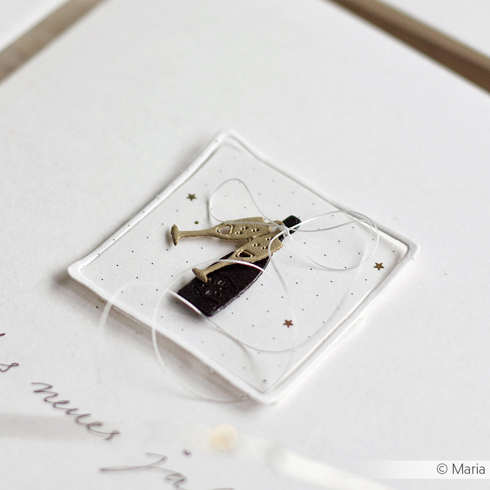 Eine quadratische Karte von Alexandra Renke aus Designpapier mit einer kleinen Sektflasche und Gläsern als Dekoration, die mit weißer Schnur und goldenen Sternen verziert ist - ideal für einzigartige Papierprojekte.