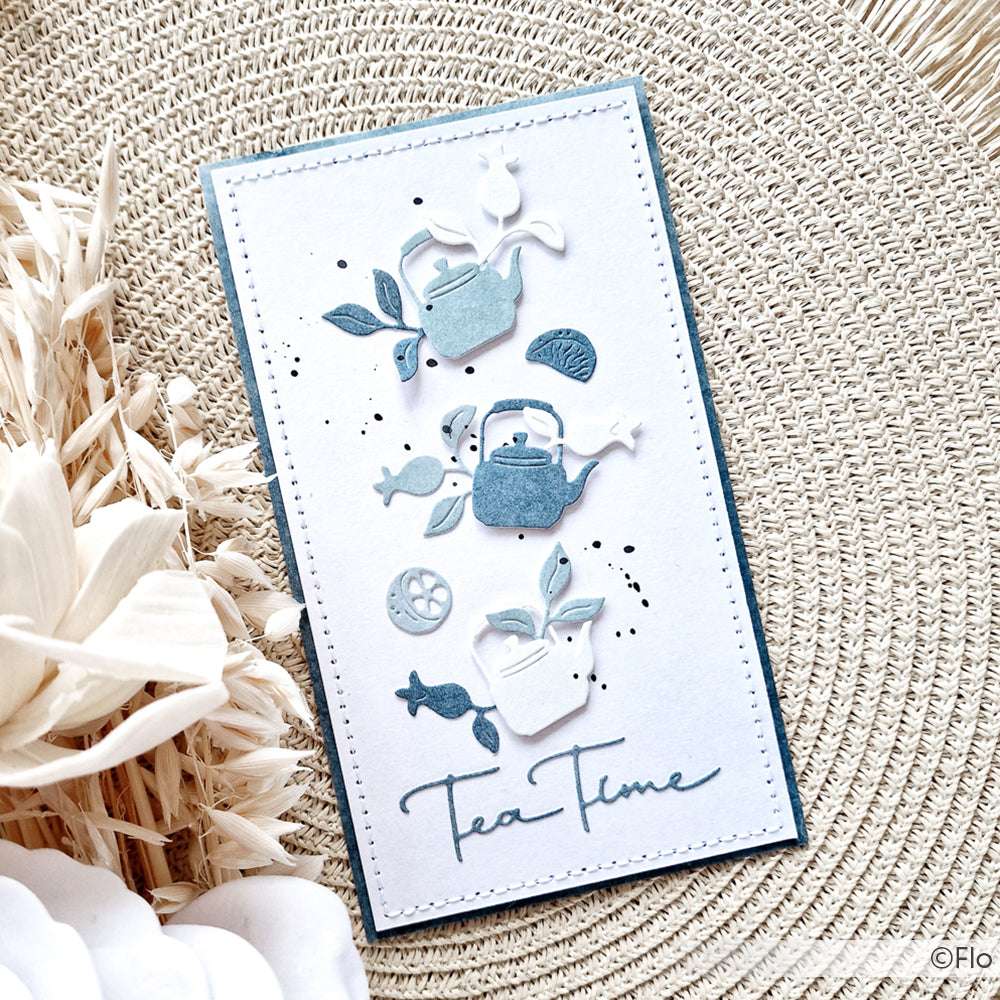 Handgemachte Karte mit blauen und weißen Teekannen, Blättern, Zitronenscheiben und dem Text "Tea Time" auf einer gewebten Oberfläche, hergestellt mit Alexandra Renke Designpapier.