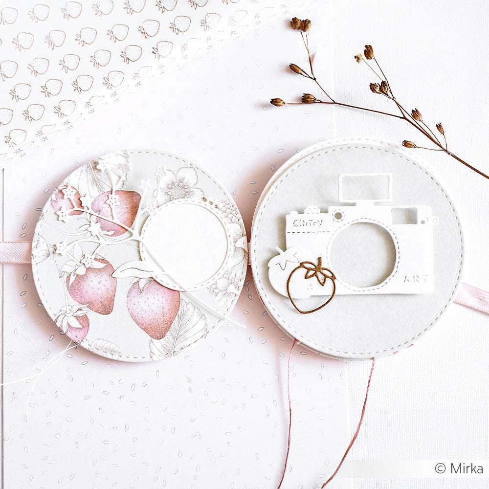 Zwei runde, pastellfarbene Bastelkarten von Alexandra Renke Designpapier zeigen Erdbeeren und ein weißes Kameramotiv auf hellem, floralem Hintergrund - ideal für Papierprojekte und einen Erdbeertraum auf Transparentgrün.