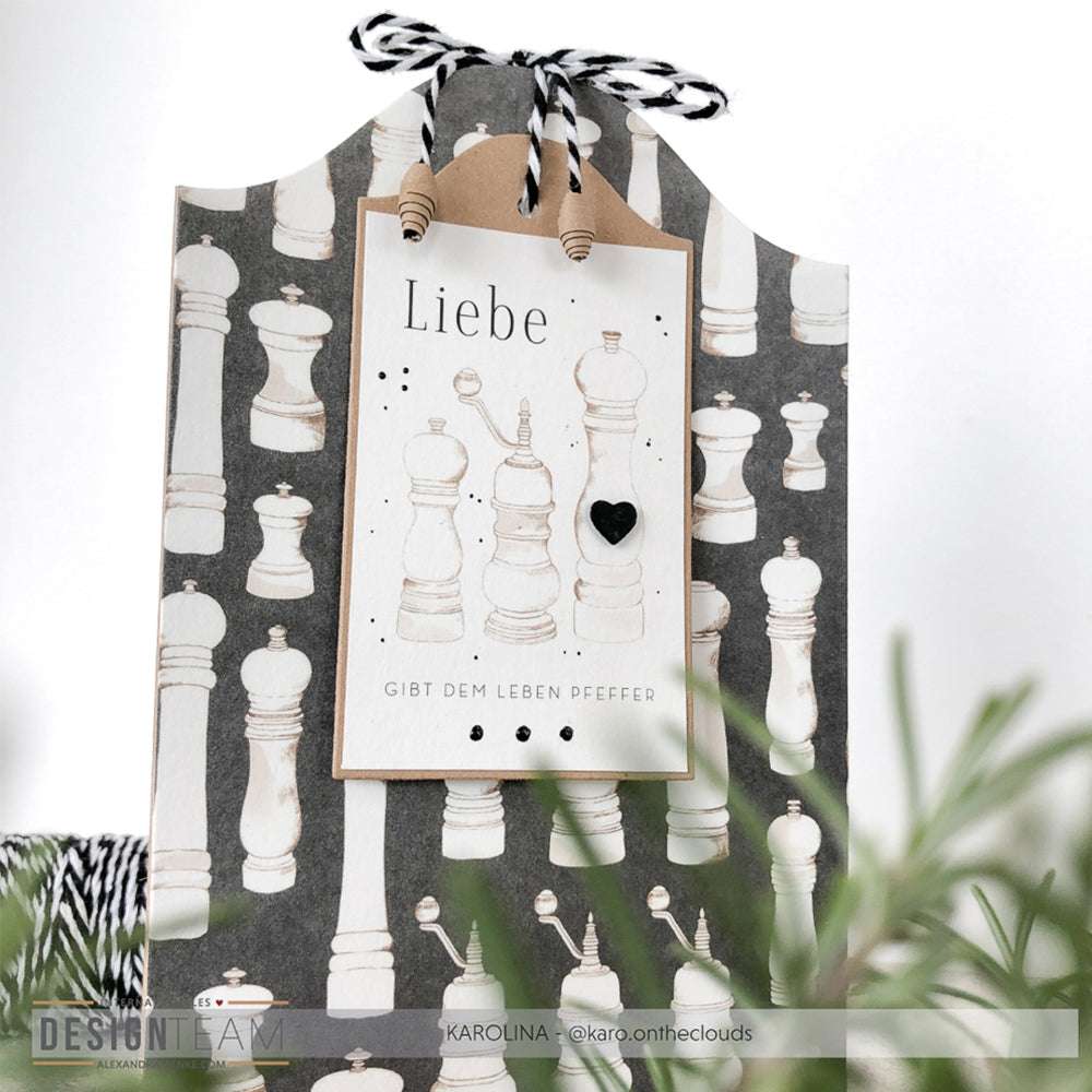 Geschenktüte von Alexandra Renke mit Schachfigurenmuster, gefertigt aus Designpapier. Mit "Liebe"-Anhänger und schwarz-weißer Kordel - perfekt für Papierprojekte oder zur Kombination mit Grußkarten.