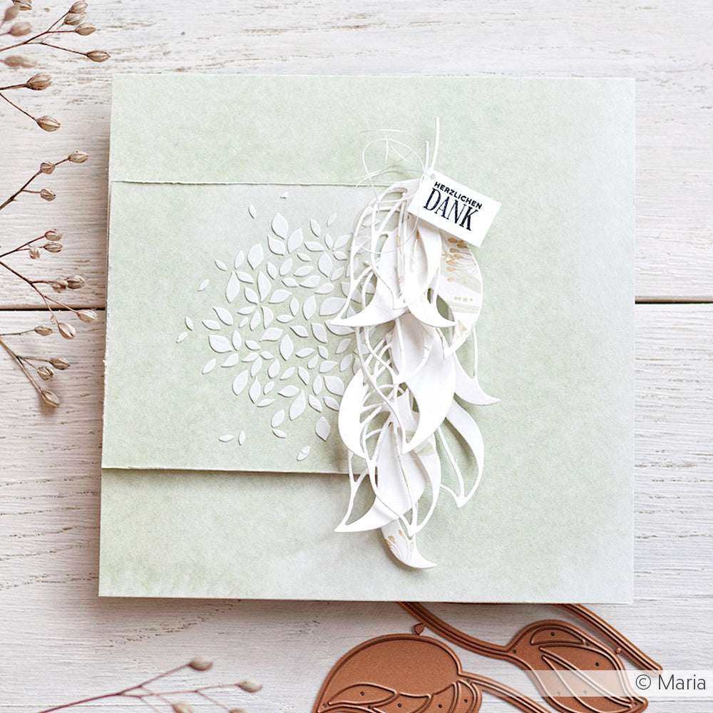 Handgefertigte Karte mit geprägten Blättern, weißen Alexandra Renke-Akzenten und einem kleinen "Dank"-Anhänger auf hellem Hintergrund - ideal für Fans von edlem Designpapier.