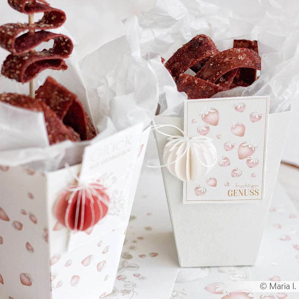 Dekorative Papierschachteln von Alexandra Renke aus Designpapier mit weißem Seidenpapier, getrockneten Fruchtsnacks und rosa Fruchtmotiven - ideal für Papierprojekte oder in Kombination mit dem Kärtchenbogen Erdbeer-Holunder.