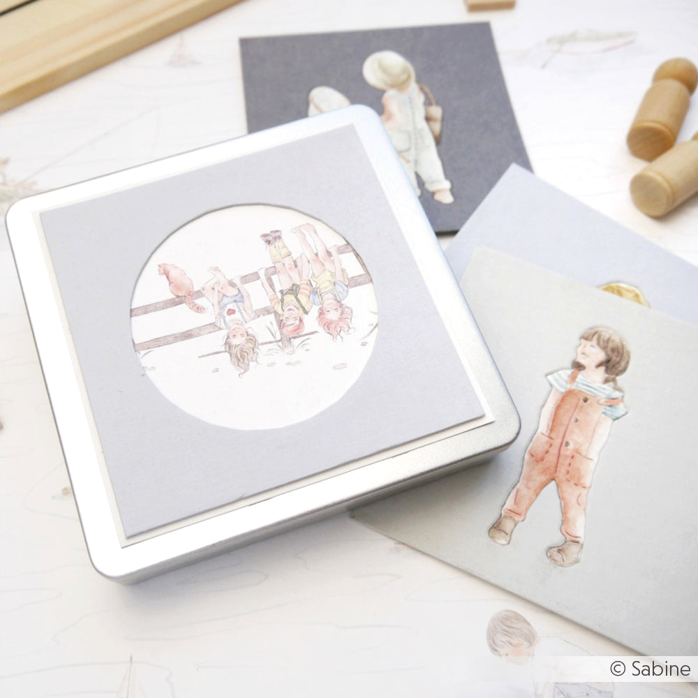 Eine Schachtel mit Kindern an einem Zaun, umgeben von Alexandra Renke Grußkarten mit aquarellierten Kindern - ideal für Papierprojekte oder zur Kombination mit Ihrem Lieblingsdesignpapier.