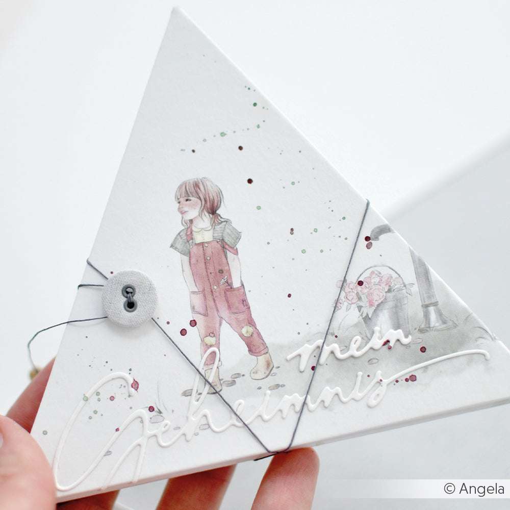 Dreieckige Karte von Alexandra Renke aus Designpapier, mit Knopf und Schnur. Mit der Illustration eines Kindes in Latzhose, das Gartengeräte in der Hand hält.