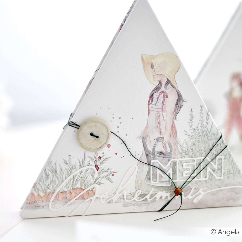 Die dreieckige Schachtel von Alexandra Renke aus Designpapier zeigt eine Frau mit Hut, Pflanzen und einen Verschluss mit Knopfleiste - ideal für sommerliche Papierprojekte zum Thema Garten.