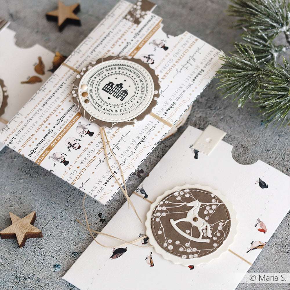 Dekorative handgemachte Weihnachtskarten von Alexandra Renke mit Winter- und Vogelmotiven auf Designpapier werden mit Tannennadeln und Holzsternen geschmückt.