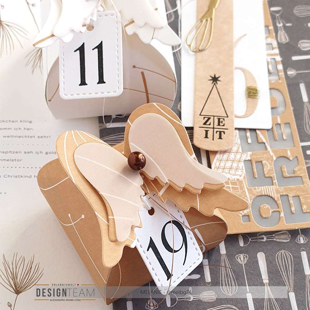 Adventskalenderboxen von Alexandra Renke mit Engelsflügeln und nummerierten Anhängern aus braunem und weißem Designpapier - ideal für kreative Papierbastel- oder Buchbinderprojekte.