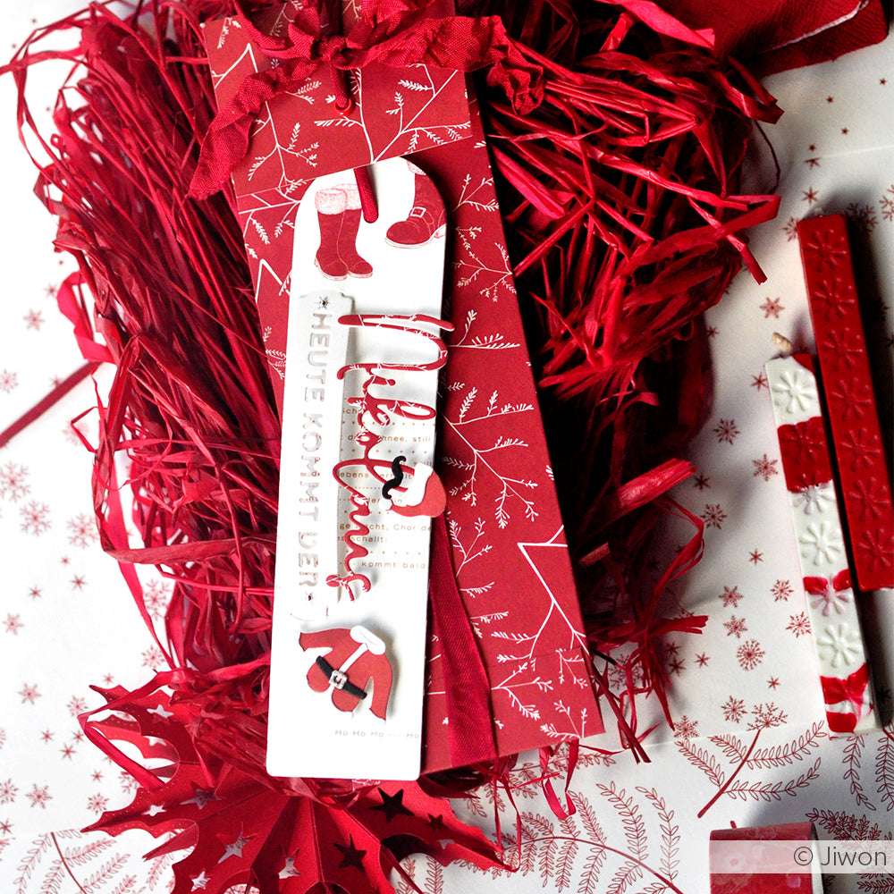 Rot-weiße Weihnachtslesezeichen aus Alexandra Renke Designpapier Winterstiefel mit weihnachtlichen Motiven werden auf rotem Raufaserpapier mit weihnachtlichem Dekor präsentiert - ideal für Ihre winterlichen Papierprojekte.