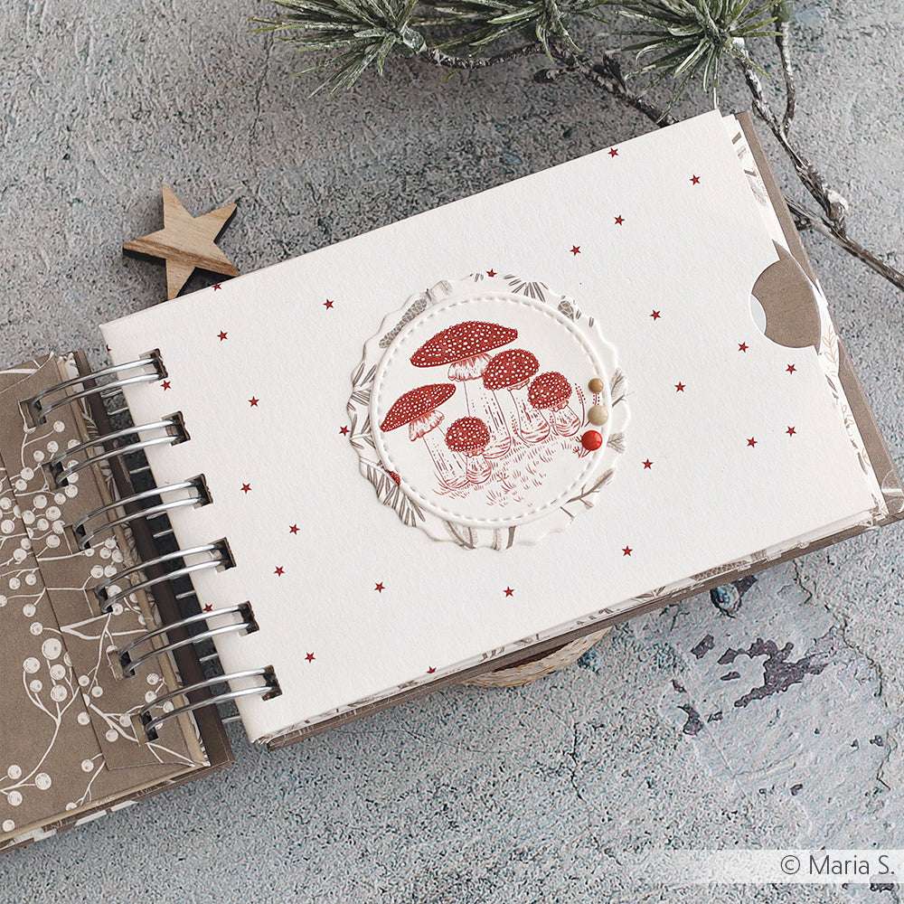 Das Skizzenbuch von Alexandra Renke mit dem Einband "Pilze im Wald" liegt auf einer strukturierten Oberfläche mit Kiefer und einem Holzstern - ideal für Ihre Papierprojekte und kreative Designpapier-Inspiration.