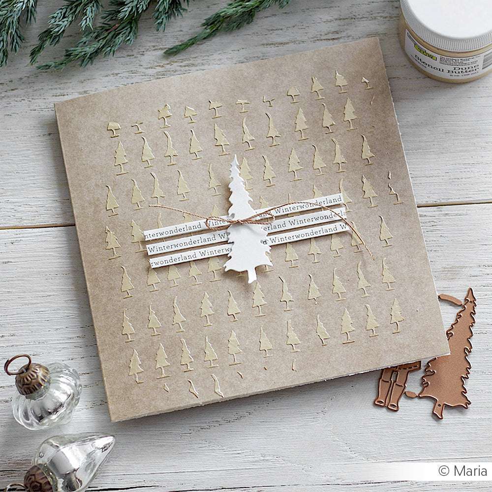 Handgemachte Grußkarte von Alexandra Renke mit kleinen Baumausschnitten, einem erhabenen Baum und Winterwonderland-Streifen aus Designpapier auf einer hellen Holzoberfläche. Ideal für Papierprojekte und Wintergrüße.