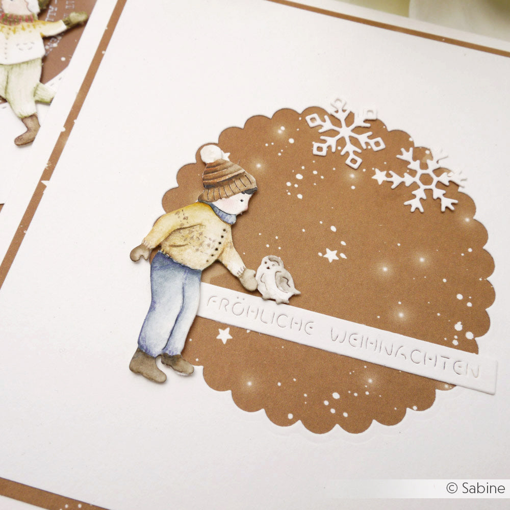 Handgefertigte Weihnachtskarte von Alexandra Renke mit einem ausgeschnittenen Kind, einer Schneeflocke und "Fröhliche Weihnachten" auf braunem Grund, akzentuiert mit Aquarell-Sternenhimmel Designpapier für einen magischen Touch.