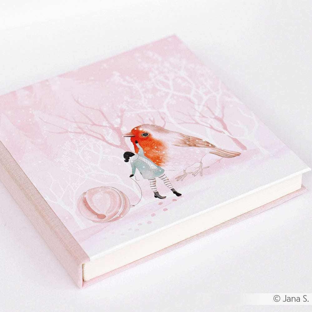 Quadratisches rosafarbenes Buch von Alexandra Renke mit einer Rotkehlchen-Winter-Freundschaft und Mädchen im verschneiten Wald - ideal für Designpapier-Fans und kreative Papierprojekte.