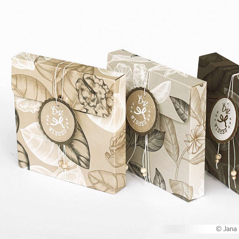 Drei Alexandra Renke Geschenkumschläge im Walnuss Floral Design, jeweils mit einem Glückwunschanhänger und einer dekorativen Kordel, werden in einer Reihe präsentiert.