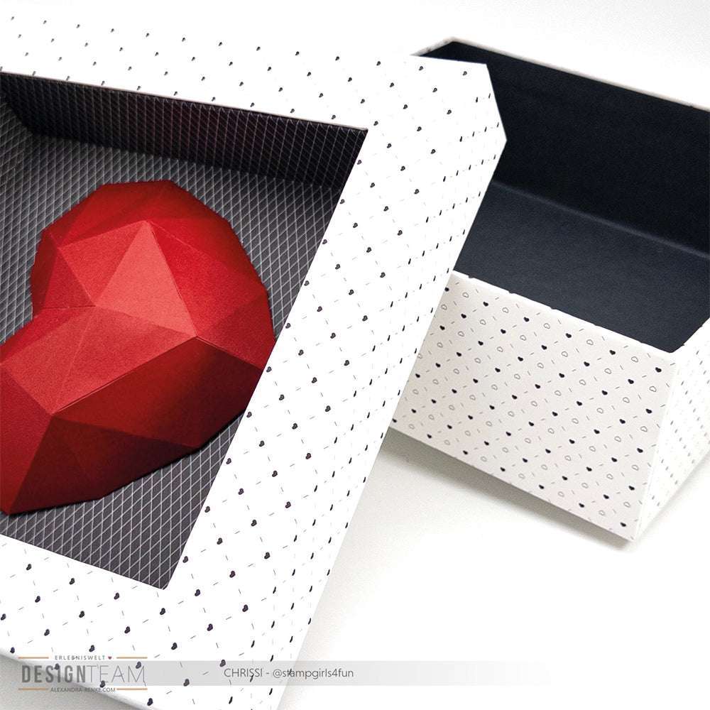 Ein geometrisches rotes Herz in einer gemusterten offenen Geschenkbox mit dunklem Innenleben - die perfekte Inspiration für Fans von Alexandra Renke Designpapier und modernen Buchbinderei Papierprojekten.