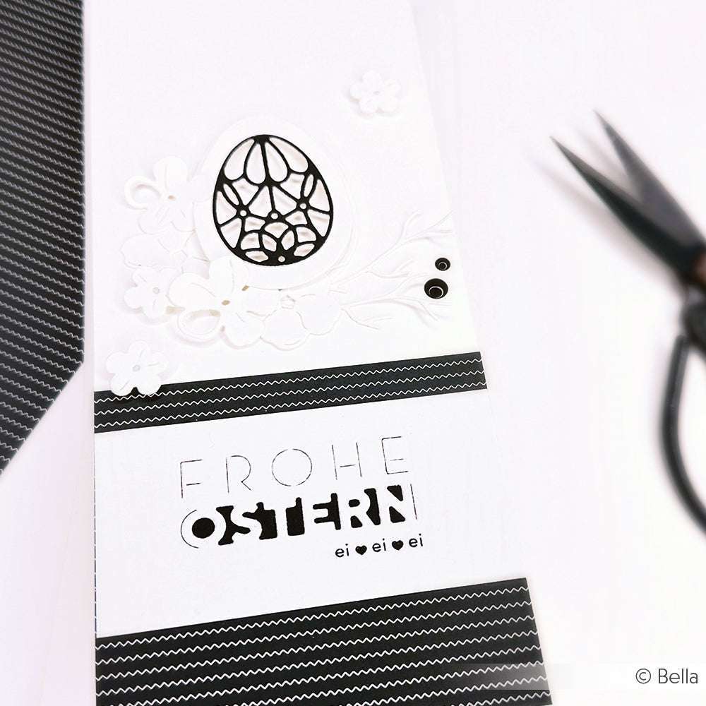 Minimalistische schwarz-weiße Osterkarte von Alexandra Renke mit einem dekorativen Ei, Blumen und "Frohe Ostern" - ideal für Papierprojekte oder als Inspiration für Ihre nächste Buchbinderei-Kreation.