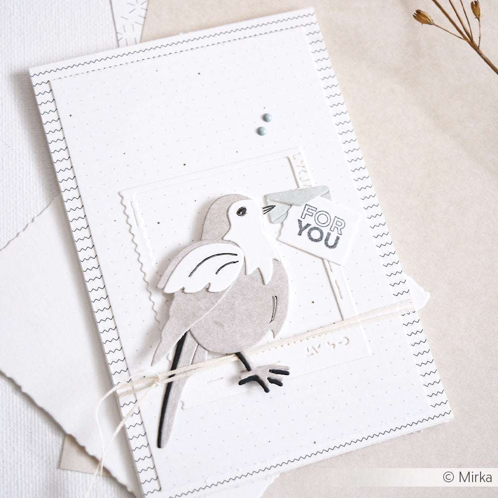 Die handgefertigte Karte von Alexandra Renke aus Designpapier zeigt einen grauen Papiervogel, der einen "FOR YOU"-Anhänger im Schnabel hält, vor einem charmanten gepunkteten Hintergrund.