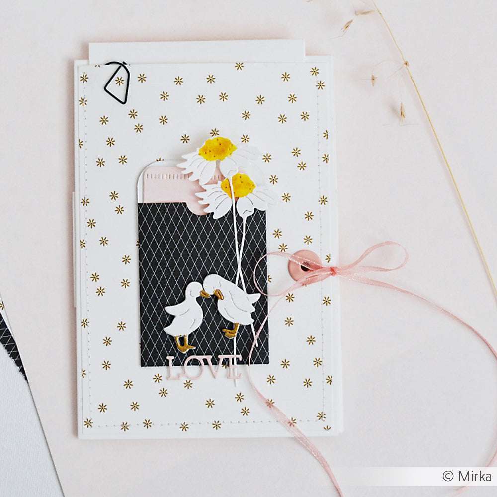 Handgefertigte Karte von Alexandra Renke mit zwei Enten, Gänseblümchen und "LOVE" auf einer schwarzen Designpapiertasche, gebunden mit rosa Schnur. Perfekt für Papierprojekte, verziert mit zarten Streublümchen Gold-Akzenten.