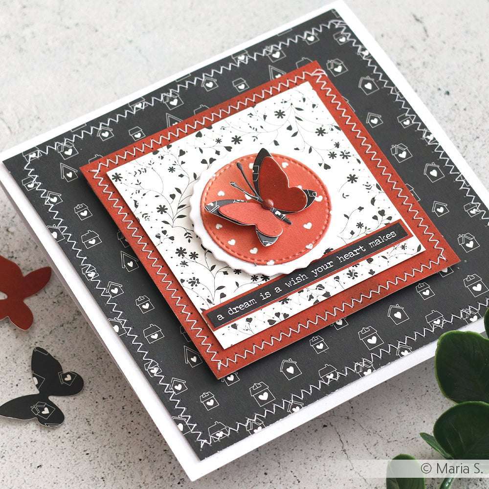 Handgefertigte Karte mit schwarzem, weißem und rotem Designpapier-Muster von Alexandra Renke, einem Schmetterling und dem Zitat "Ein Traum ist ein Wunsch, den dein Herz macht" - ideal für einzigartige Papierprojekte oder Buchbinderei-Inspiration.